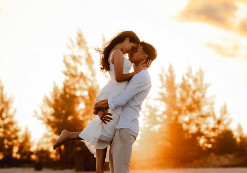 A romantic couple embraces on a beach at sunset in Ilha Comprida, Brazil.